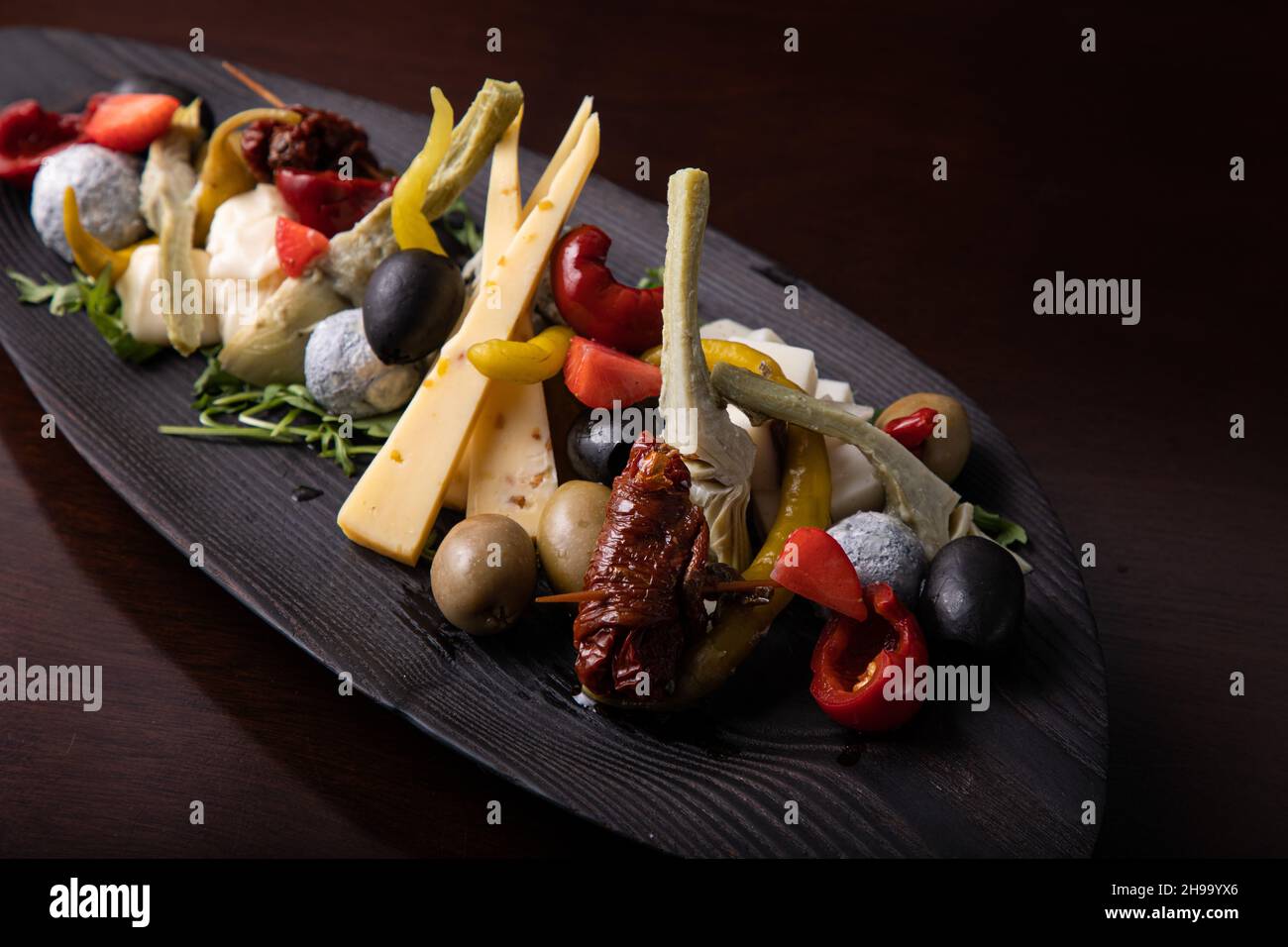 Palette von vielen Arten von Käse und etwas Gemüse, Tomaten, Paprika, Oliven. Stockfoto