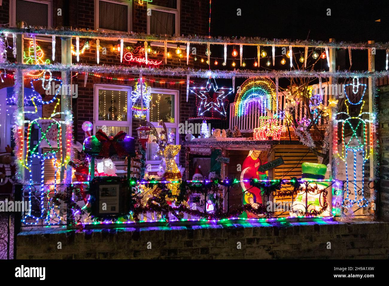 London, Großbritannien. 5th Dez 2021. Wie jedes Jahr haben die Besitzer eines Hauses im Honor Oak Park, im Südosten Londons, ihr „Christmas House“ liebevoll mit hellen und farbenfrohen Lichtskulpturen, festlichen Figuren und Illuminationen dekoriert, wobei Schnee auf die Bühne fällt. Die Installation dient einer wohltätigen Organisation, dem diesjährigen Macmillan Cancer Support, und die Familie nimmt auch an der 26 Meilen langen South Coast Mighty Hike von Macmillan Teil, um Spenden für die Wohltätigkeitsorganisation zu sammeln. Kredit: Imageplotter/Alamy Live Nachrichten Stockfoto