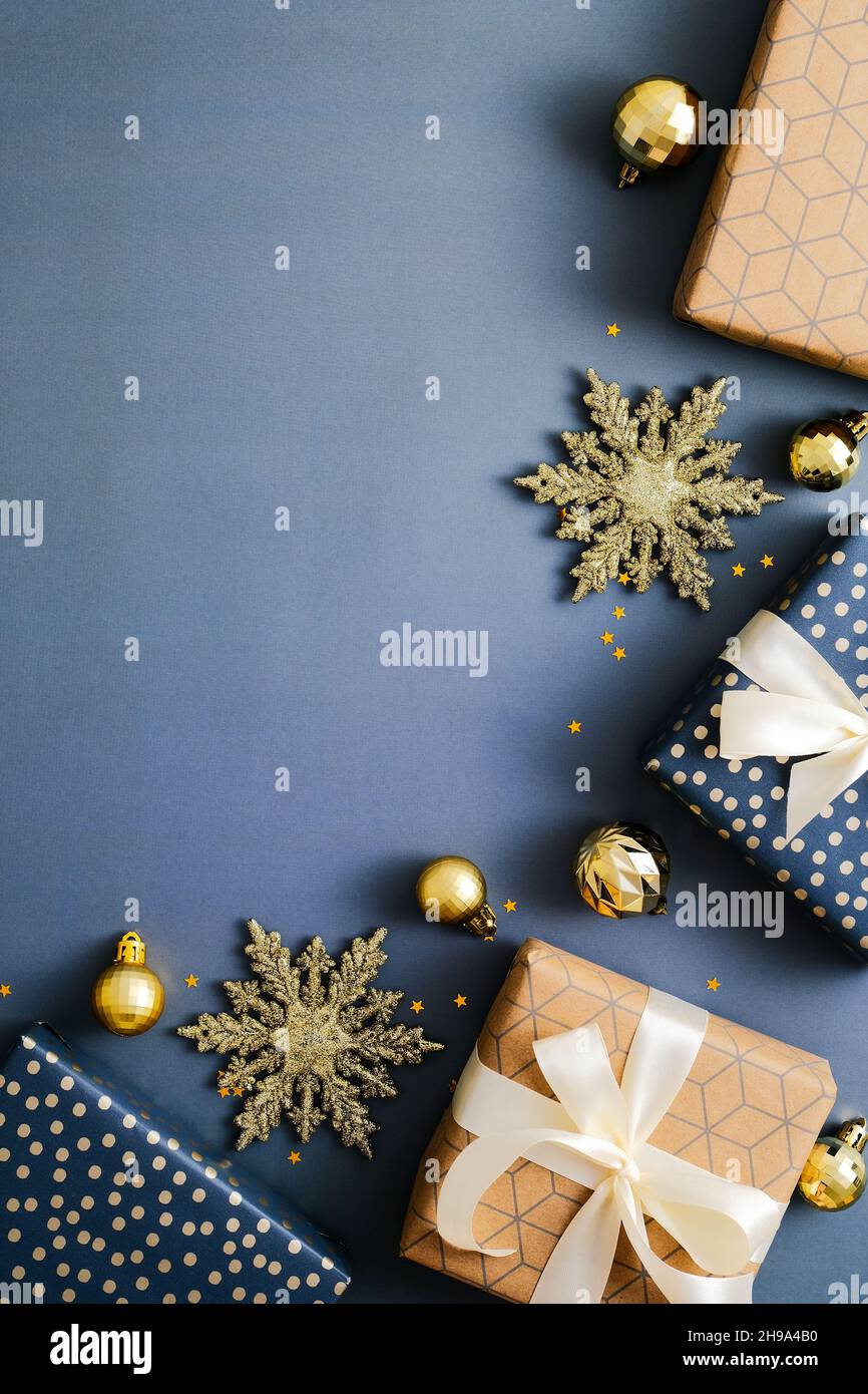 Weihnachten vertikalen blauen Hintergrund, Weihnachts-Poster, Social-Media-Geschichten Banner-Design. Flache Weihnachtsgeschenkschachteln und goldene Dekorationen auf blauem Rücken Stockfoto