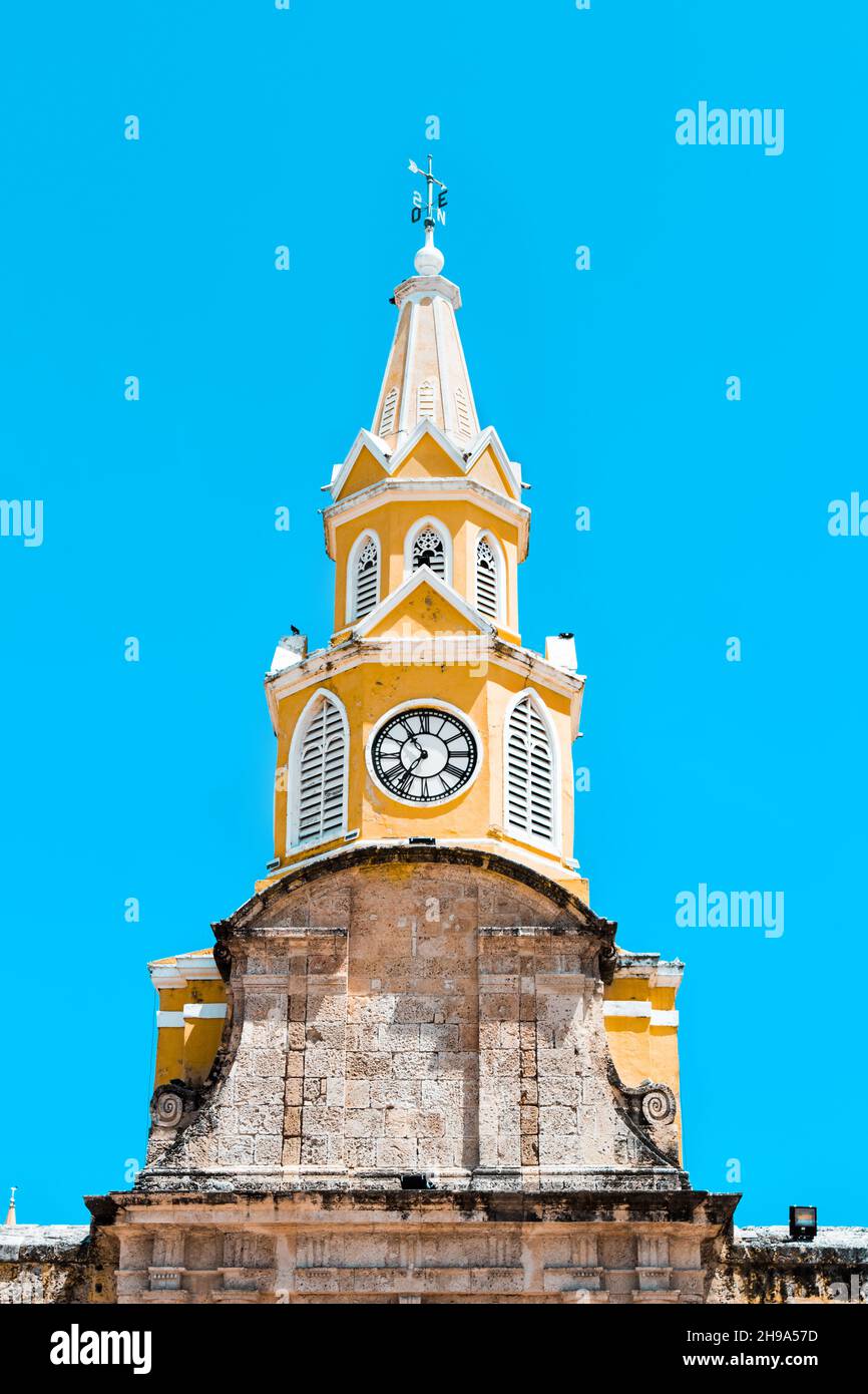 Die Puerta del Reloj, Torre del Reloj oder Boca del Puente (Uhrturm-Denkmal) atemberaubend und leuchtend gelb in Cartagena, Kolumbien an einem Sommertag. Stockfoto