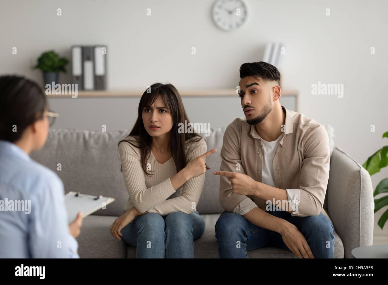 Unglückliche arabische Ehepartner beschuldigen sich gegenseitig in Beziehungsproblemen beim Treffen mit dem Familienberater Stockfoto
