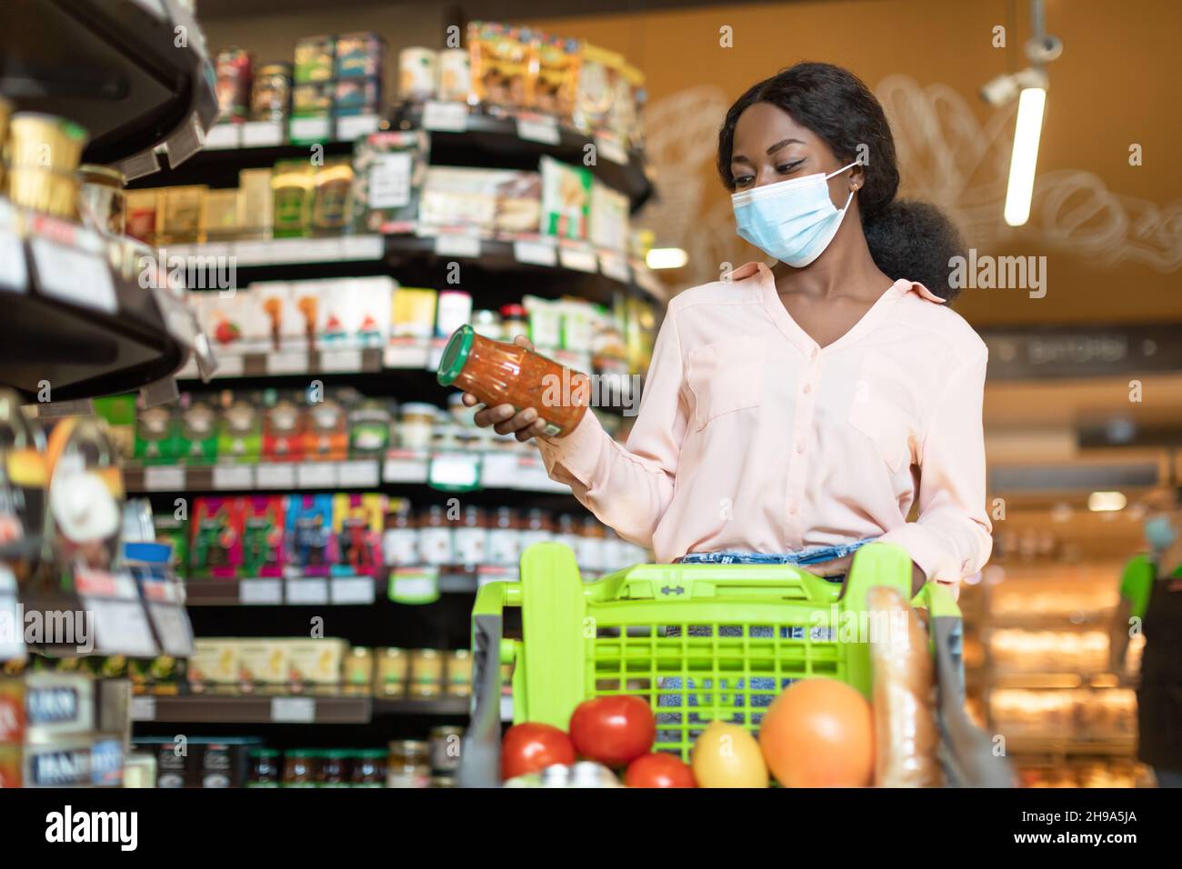 Afrikanische Frau Einkaufen Trägt Gesichtsmaske Halten Jar Im Supermarkt Stockfoto