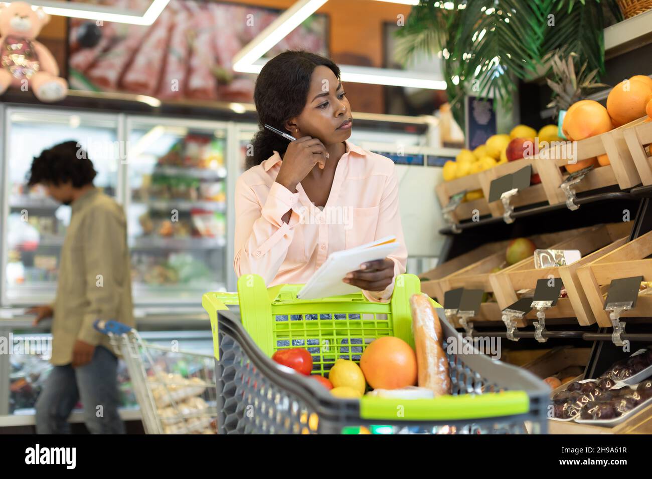 Black Lady Holding Lebensmittelgeschäft Einkaufsliste Berechnung Der Preise Im Supermarkt Stockfoto
