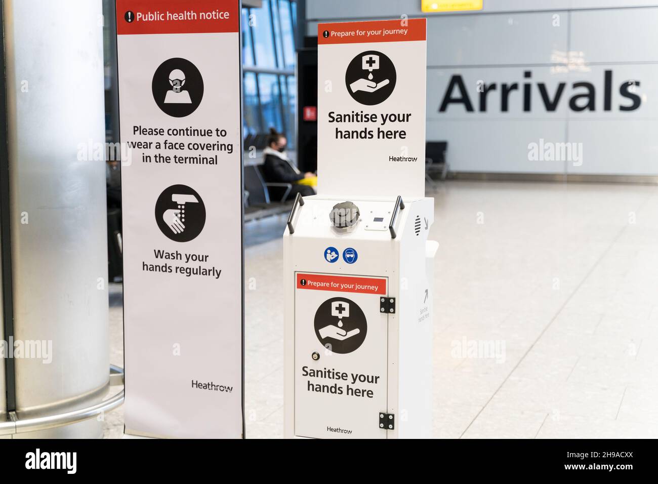 Gesundheitshinweise und Schilder, die im Rahmen der Covid-19-Pandemie am Terminal des Flughafens London Heathrow, England, um die Hände zu desinfizieren Stockfoto