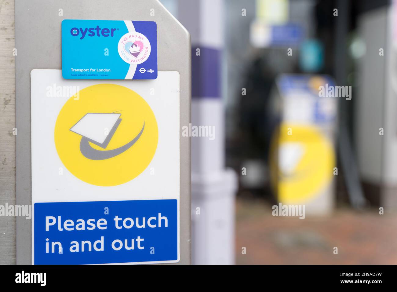 Der Aufkleber „Ich habe meine CVOID-Impfung“ auf der TFL Oyster-Karte berührt einen Kartenleser am Bahnhof London England Großbritannien Stockfoto