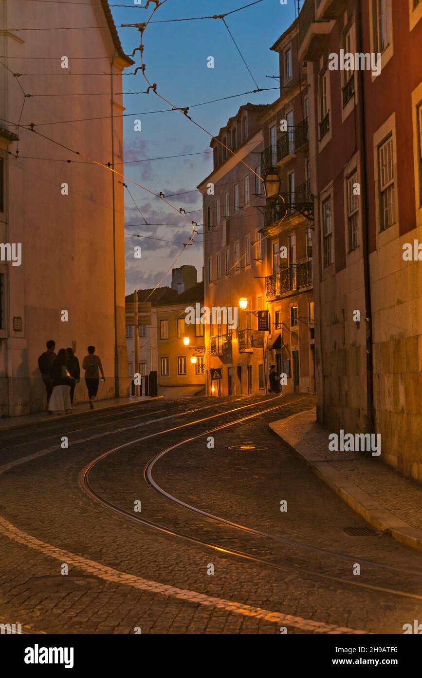 Nachtansicht der Straßenbahnschienen, die durch die Kopfsteinpflasterstraße in Alfama führen, einem der ältesten Viertel Lissabons, Lissabon, Portugal Stockfoto