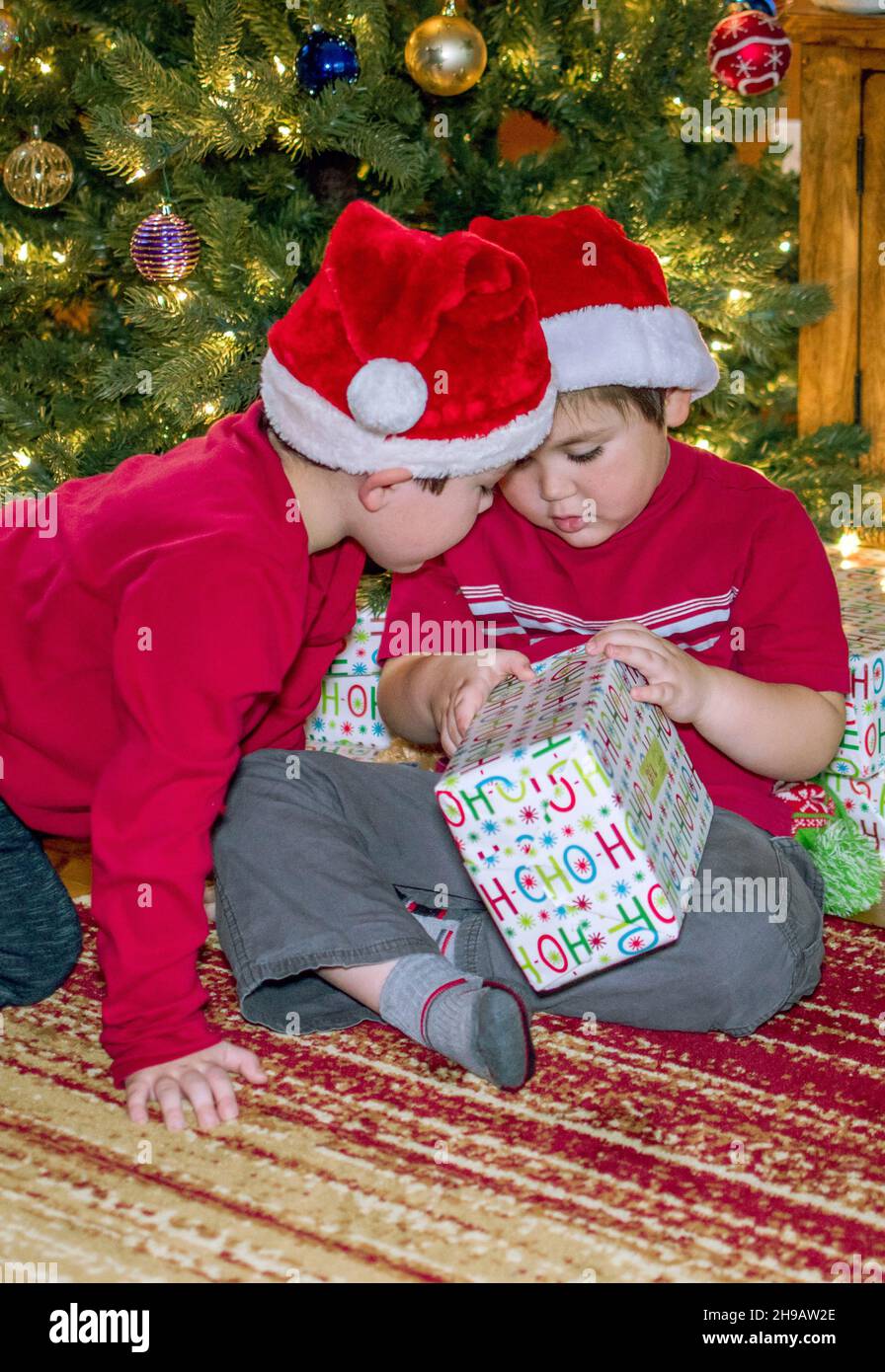 Ein Bruder prüft das Geschenk, das sein Bruder öffnet. Stockfoto
