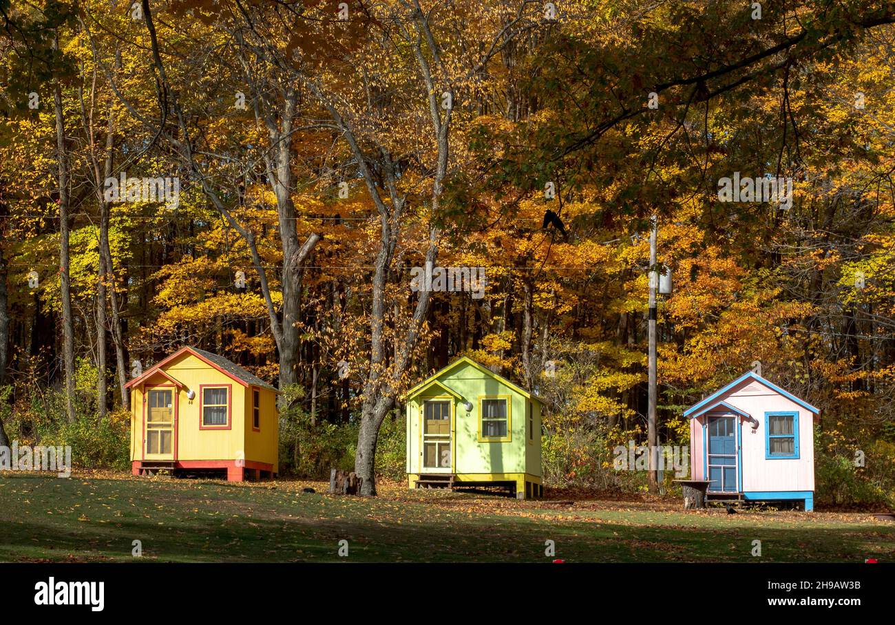 Kleine Hütten in Pastellfarben stehen in diesem rustikalen Zeltplatz zur Miete zur Verfügung Stockfoto