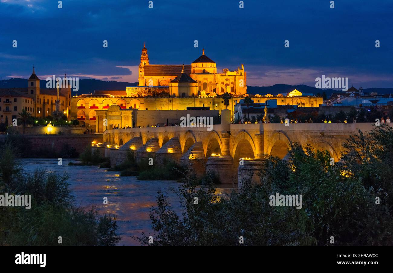 Nachtansicht der römischen Brücke auf dem Guadalquivir-Fluss und der Mezquita-Kathedrale (Moschee-Kathedrale oder große Moschee von Cordoba), Cordoba, Spanien Stockfoto