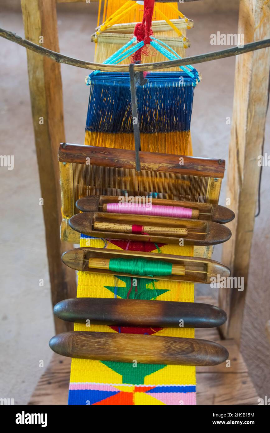 Webstuhl und Spulen aus Fäden zum Weben von Kente-Stoffen, einer Art Seide und Baumwollstoff aus gewebten Stoffstreifen, die aus der ethnischen Gruppe der Akan hergestellt wurden Stockfoto