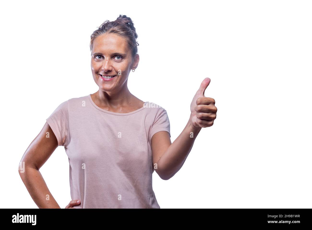 Lächelnde Erwachsene Frau zeigt Daumen auf weißem Hintergrund Stockfoto