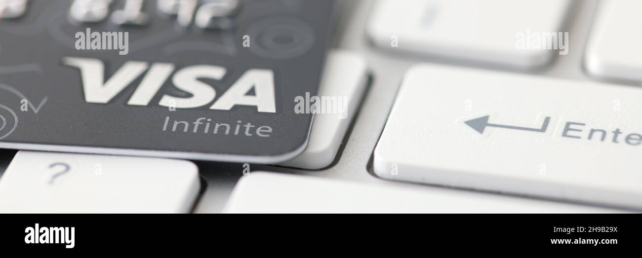 Minsk, Weißrussland - 06 2021. August: Visa Infinite credit plastic Card lies on keyboard closeup Stockfoto