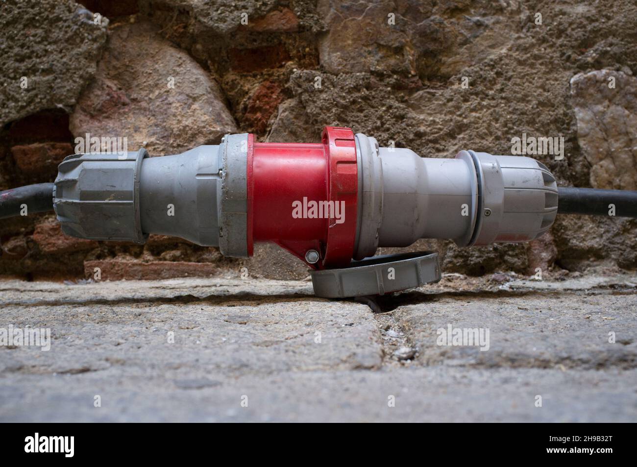 Hochspannungssteckverbinder, der vom Generator über das Altstadtgelände kommt. Selektiver Fokus Stockfoto