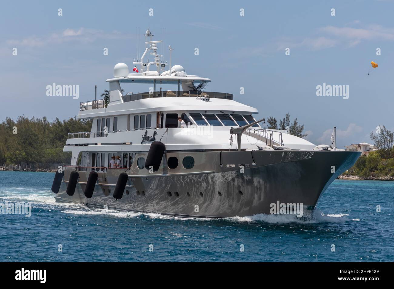 Nassau, Bahamas - 14. Mai 2019: Luxusyacht Loon segelt im Hafen von Nassau. Einige Crew-Mitglieder auf offenen Decks. Türkisfarbenes Wasser im Vordergrund. Sh Stockfoto