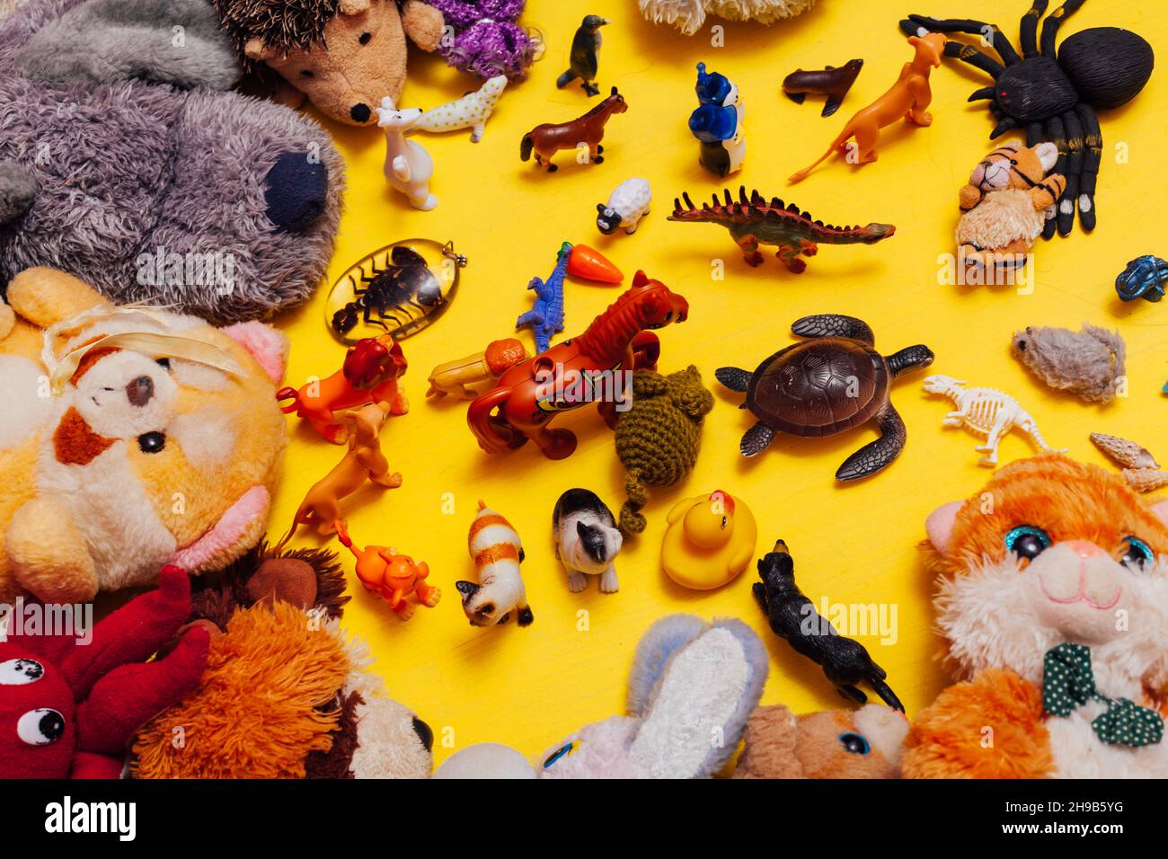 Viele Kinderspielzeuge von Tieren auf gelbem Hintergrund Stockfoto