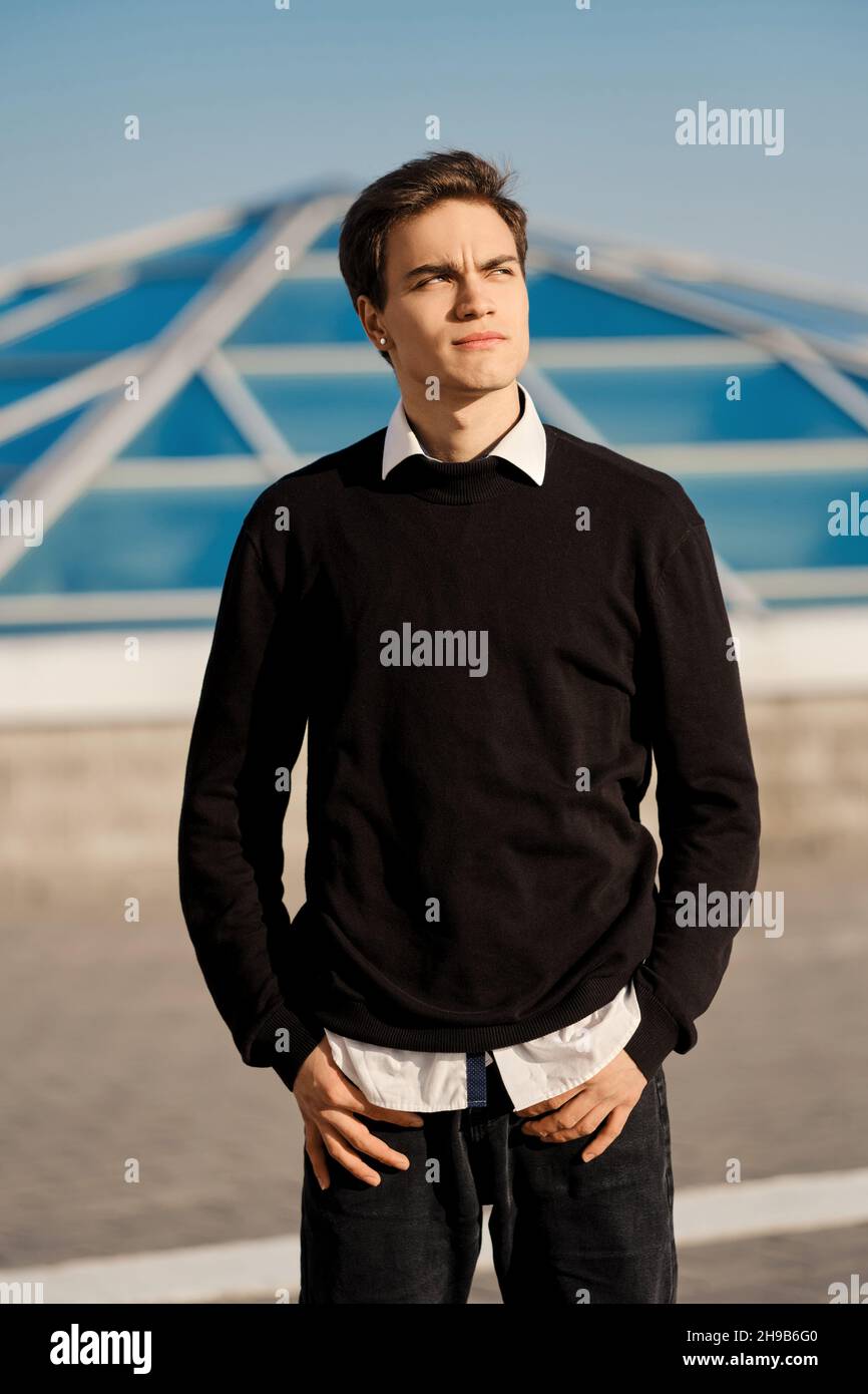 Außenportrait eines jungen Mannes in weißem Hemd, der unter einem Pullover  hervorsteht Stockfotografie - Alamy