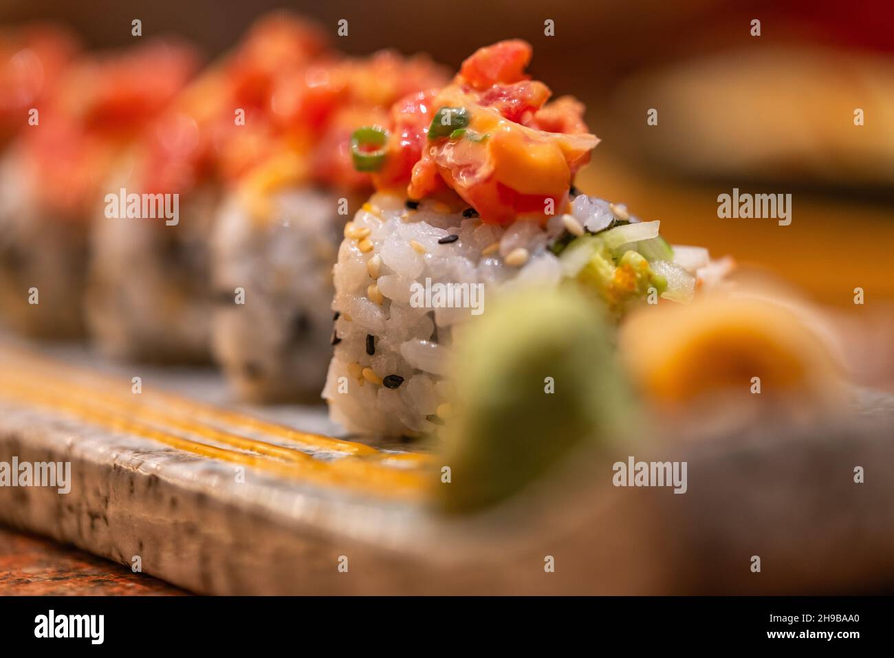 Makro-Sushi-Rolle mit würzigem rohem Thunfisch auf einem schönen Steinteller, gesundes japanisches Essen, ausgewählter Fokus. Stockfoto