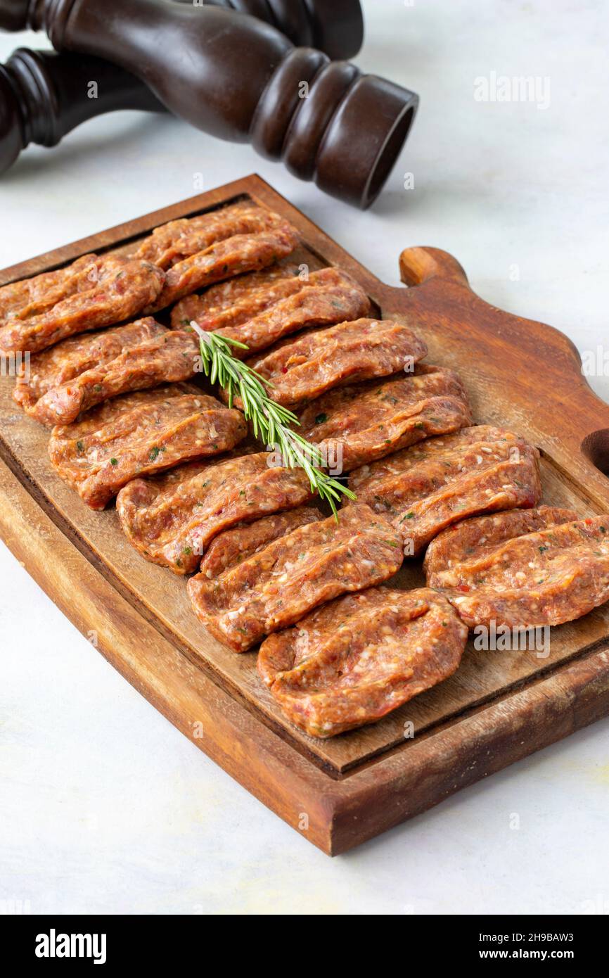 Würzige rohe Fleischbällchen auf Holzhintergrund. Türkische Fleischbällchen Stockfoto