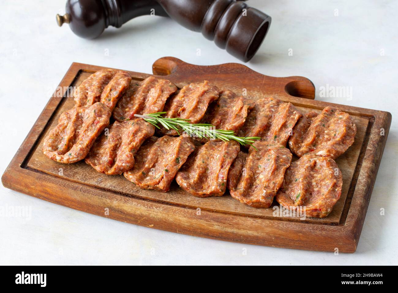 Würzige rohe Fleischbällchen auf Holzhintergrund. Türkische Fleischbällchen Stockfoto