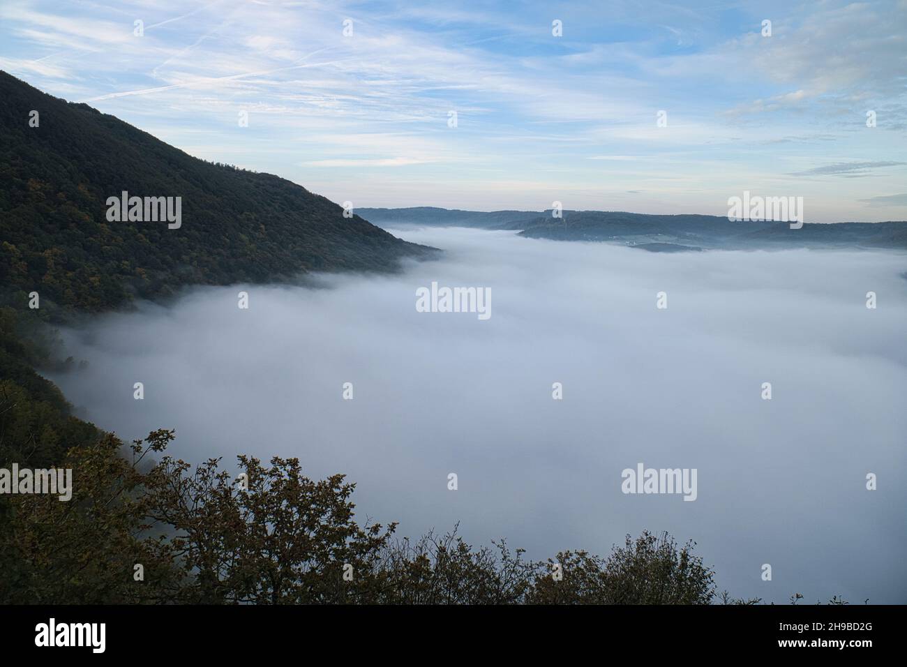 Nebel steigt auf den Bergen der kleinen Saarschleife. Mystische Stille an der Saar im Saarland. Stockfoto