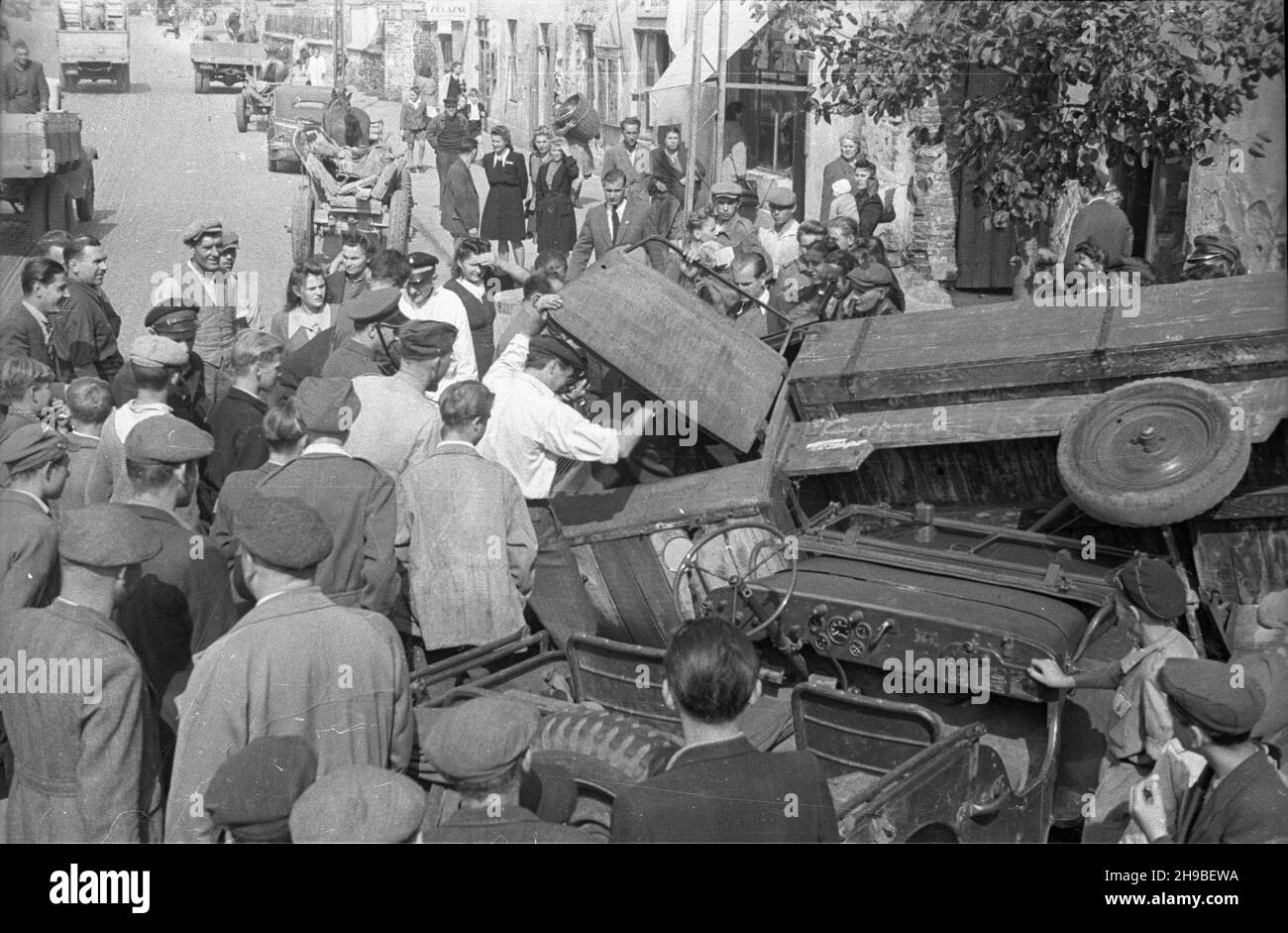 Warszawa, 1947-09. Wypadek samochodowy na ul. Marsza³kowskiej. NZ. Ludzie pomagaj¹ wydostaæ siê kierowcy uwiêzionemu w przewróconej ciê¿arówce. po/mgs PAP Dok³adny dzieñ wydarzenia nieustalony. Warschau, September 1947. Ein Autounfall in der Marszalkowska-Straße. Im Bild: Passanten helfen einem Fahrer des Lastwagens beim Aussteigen. po/mgs PAP Stockfoto