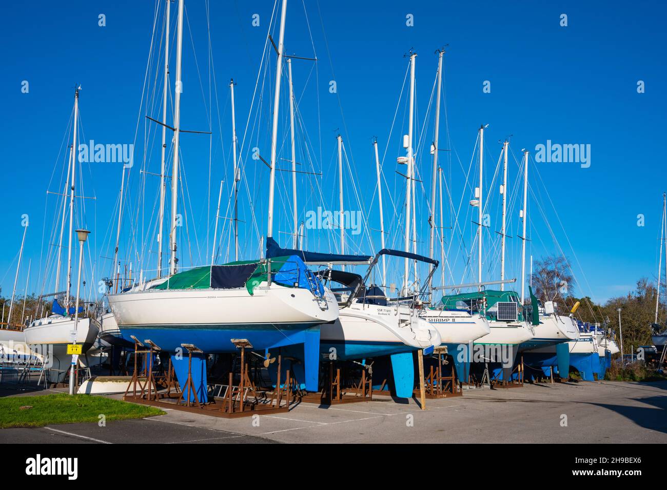 Yachten (Segelboote) an Land zur Lagerung und Wartung bei der Bosham Yacht Company in Bosham Village, West Sussex, England, Großbritannien. Stockfoto