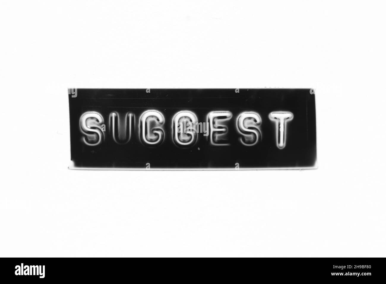 Schwarzes Banner mit geprägtem Buchstaben und Wort auf weißem Papierhintergrund vorschlagen Stockfoto