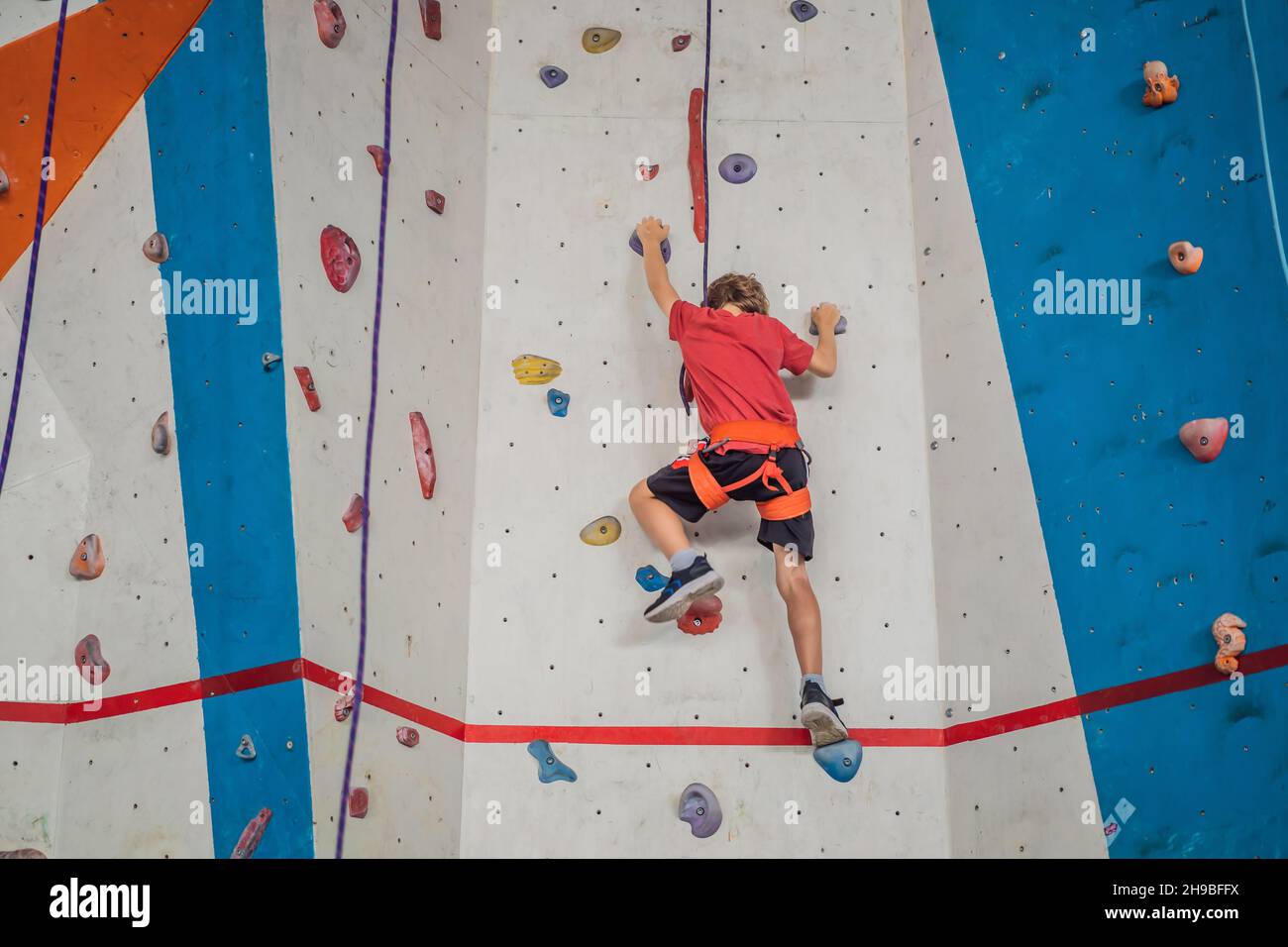 Junge an der Kletterwand ohne Helm, Gefahr an der Kletterwand Stockfoto