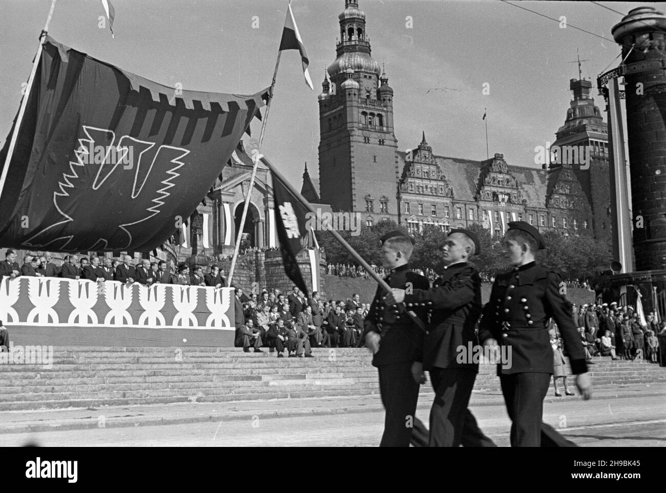 Stettin, 1947-09-07. Trzeci Zjazd Przemys³owy Ziem Odzyskanych. NZ. Defilada na Wa³ach Chrobrego. Maszeruj¹ uczniowie szkó³ przysposobienia przemys³owego. Z lewej przedstawiciele rz¹du na trybunie honorowej. W tle widoczny gmach dawnej rejencji szczeciñskiej z lat 1901-1921. po/ms PAP Stettin, 6. September 1947. Der Industriekongress der wiedergewonnenen Gebiete von 3rd. Im Bild: Eine Defilade auf Waly Chrobrego. Marching Studenten der industriellen Vorbereitung Hochschulen. Auf der linken Seite Regierungsmitglieder auf dem Paradestand. Im Hintergrund - ehemaliges Notargebäude Stettin von 1901-1921. po/ms P Stockfoto
