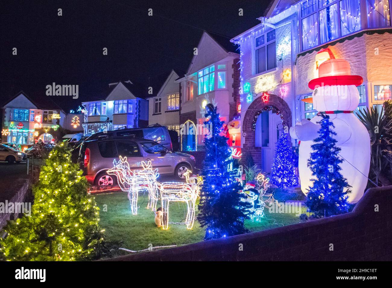 Poole, Dorset, Großbritannien. 5th. Dezember 2021. Häuser in festlichen Weihnachtslichtern an der Runton Road in Poole, Dorset. Die beleuchteten Weihnachtsausstellungen werden seit etwa zwanzig Jahren von den Bewohnern organisiert und sammeln aus Spenden der vielen Besucher Gelder für lokale Wohltätigkeitsorganisationen. Bildnachweis: Graham Hunt/Alamy Live News Stockfoto