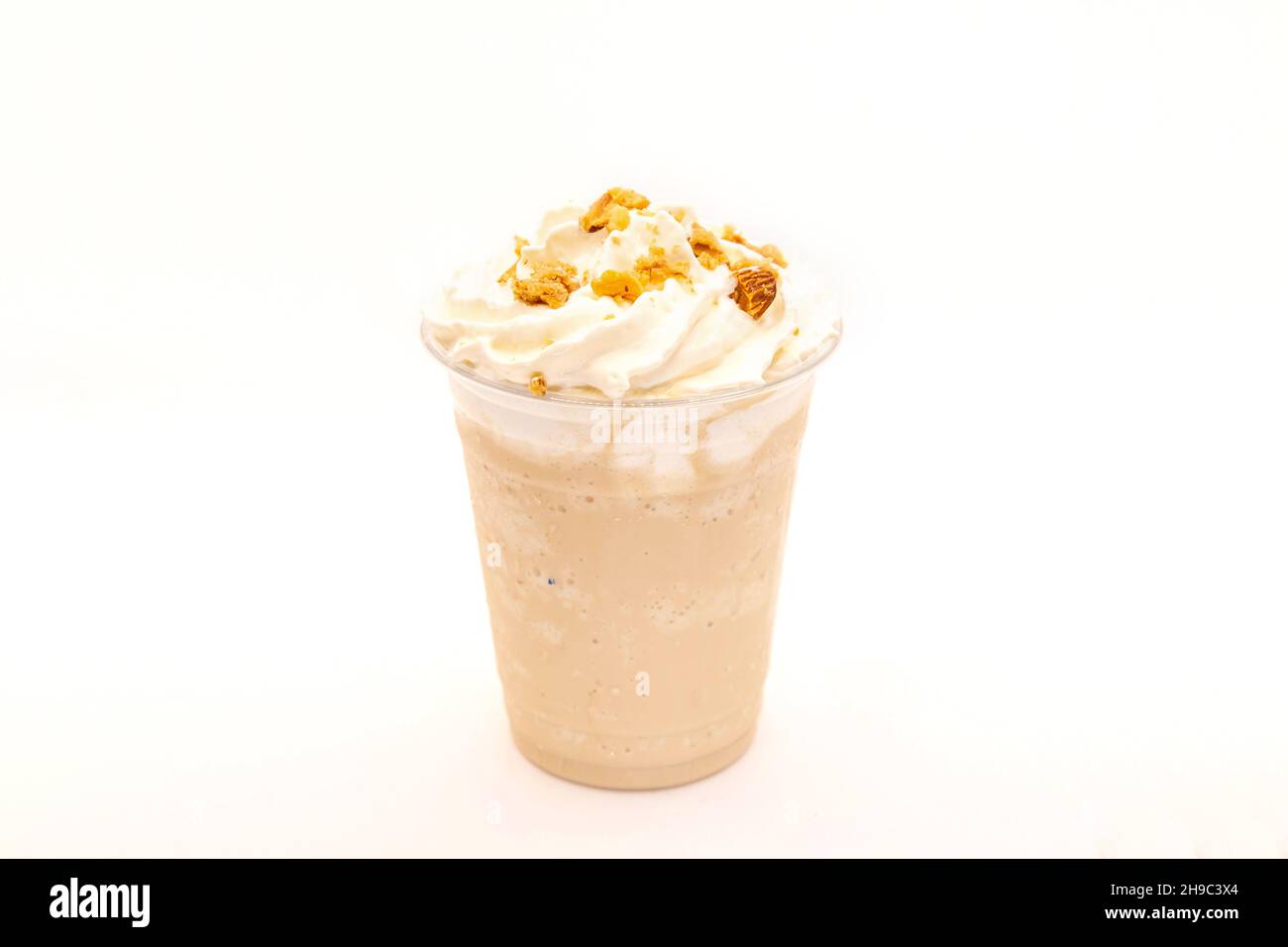 Frappe mit Haselnussgeschmack, serviert in einer Plastikbecher mit Schlagsahne und Dressing. Stockfoto