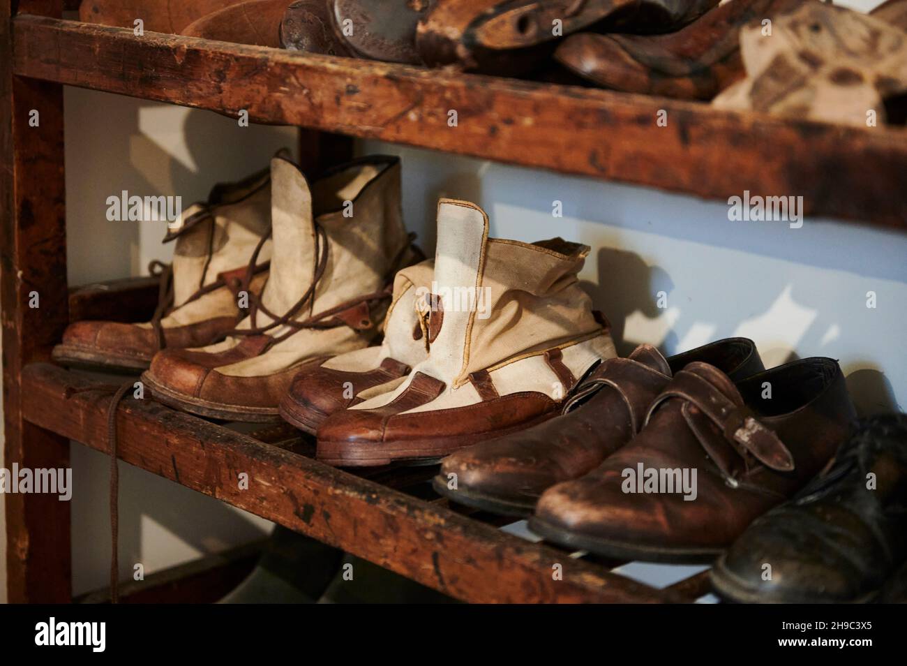 Verschiedene Vintage-Schuhe in einer Reihe auf den alten Regalen, Innenraum des Ethnographischen Museums von Artziniega, Alava, Baskenland, Euskadi, Euskal Herria, Sp Stockfoto