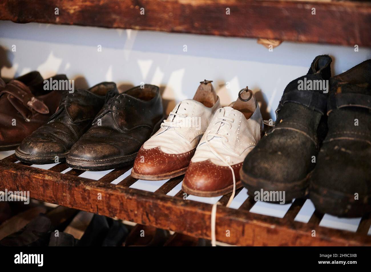 Verschiedene Vintage-Schuhe in einer Reihe auf den alten Regalen, Innenraum des Ethnographischen Museums von Artziniega, Alava, Baskenland, Euskadi, Euskal Herria, Sp Stockfoto