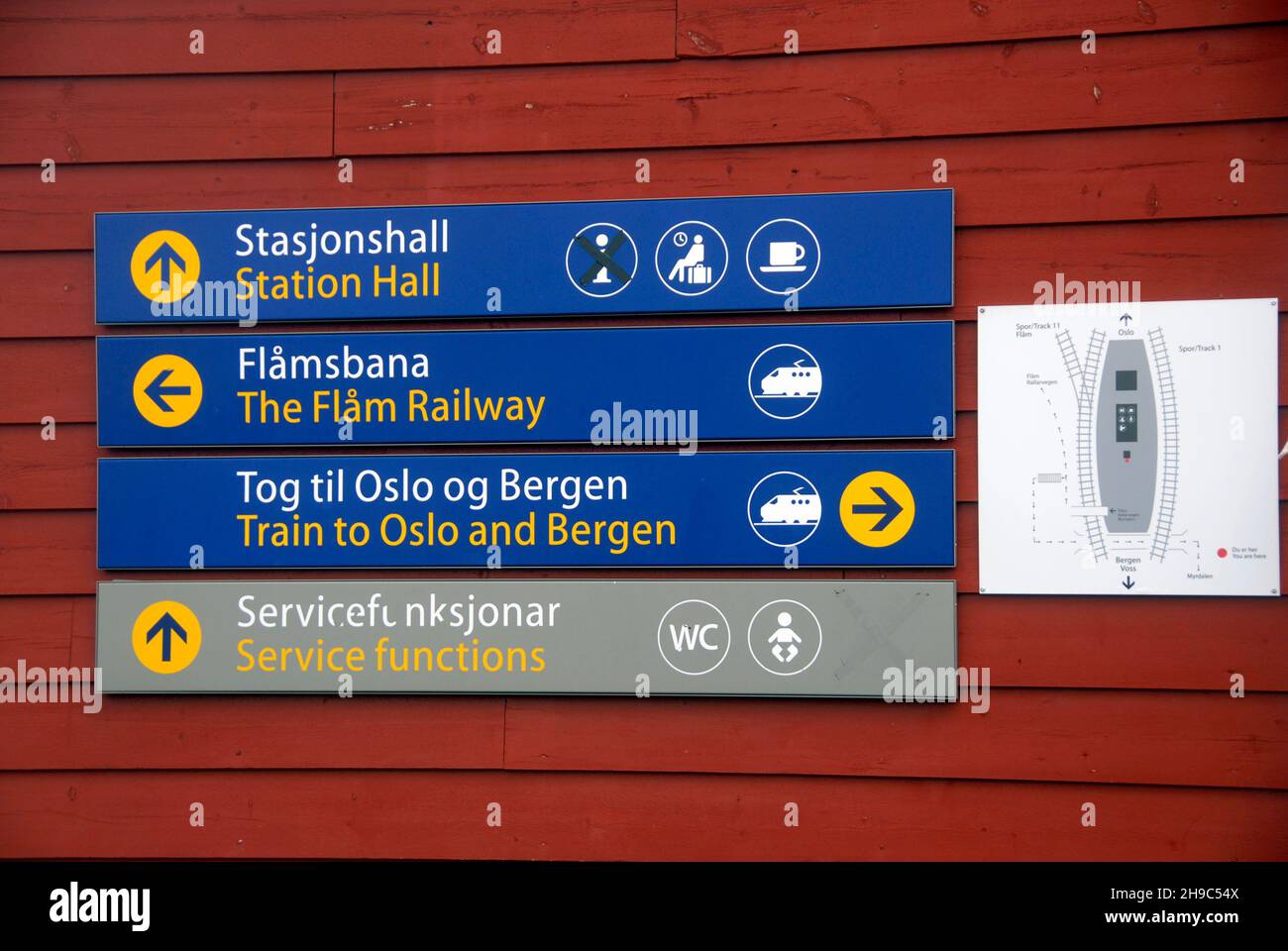 Schild am Bahnhof Myrdal, Norwegen, mit Pfeilen nach oben, links und rechts für verschiedene Ziele mit Plan des Bahnhofsauflayouts daneben Stockfoto