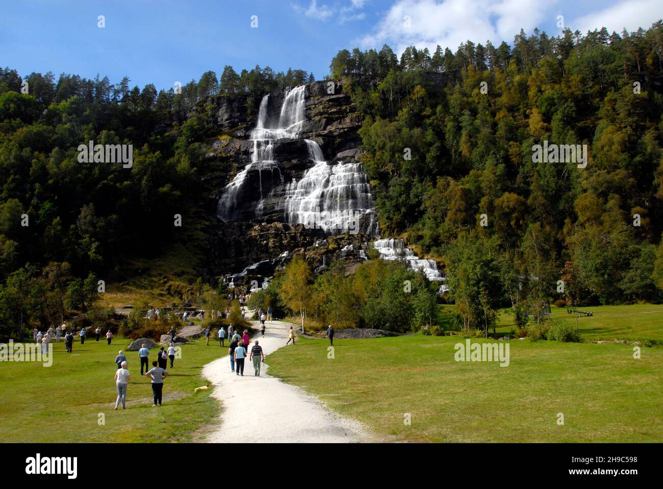 Touristen strömen, um den Tvindefossen Wasserfall, Norwegen, zu sehen Stockfoto