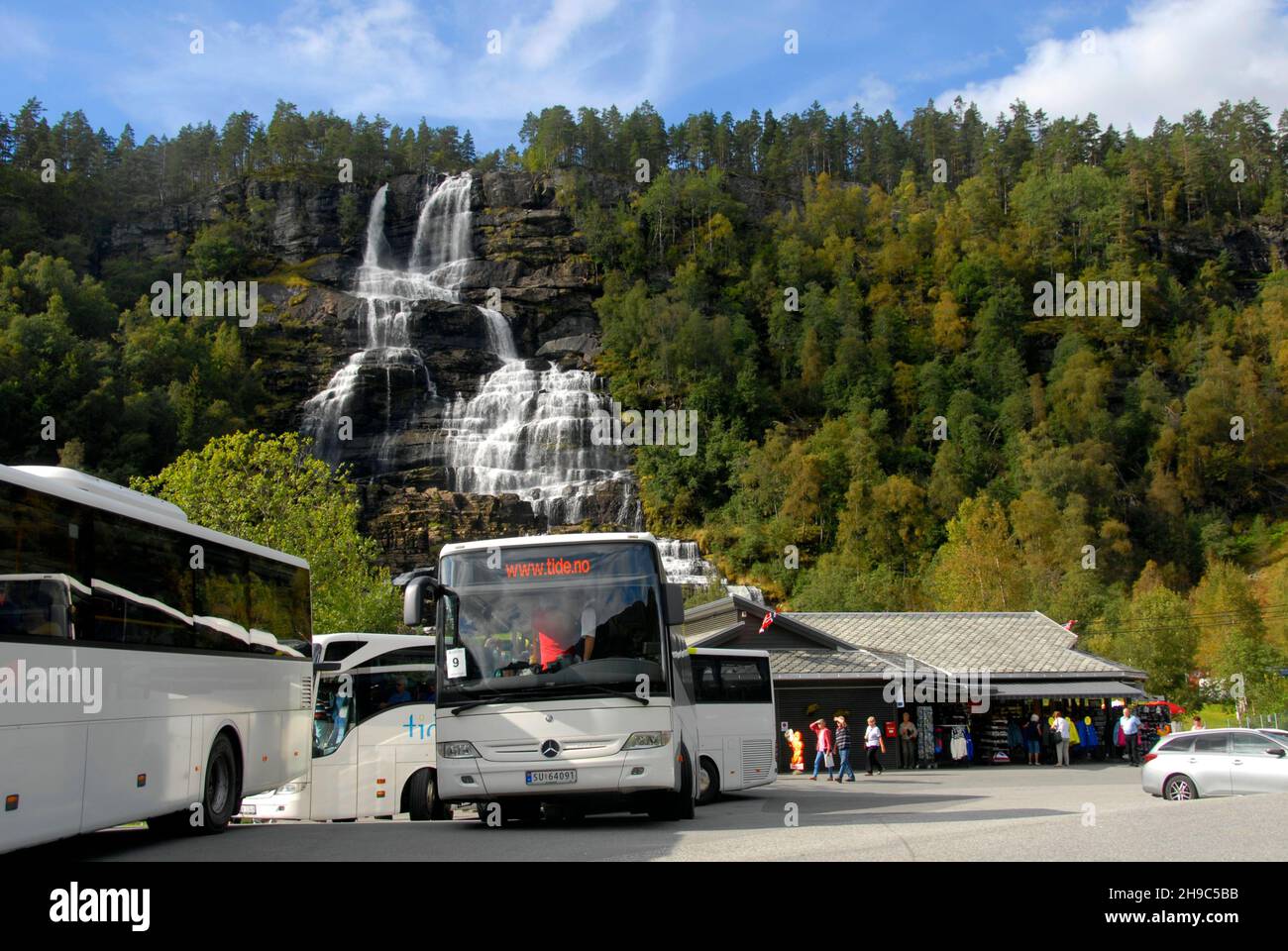 Touristenbusse am Tvindefossen Wasserfall, Norwegen, bringen Touristen zum Wasserfall Stockfoto