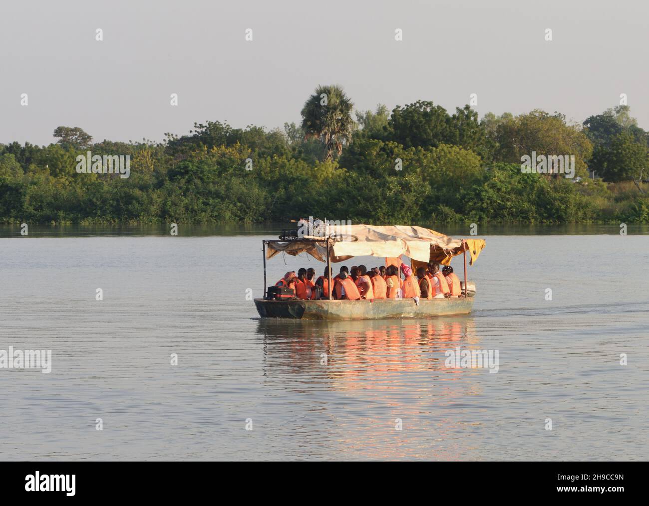 Kleine Passagierfähren transportieren Passagiere mit Schakenmantel über den Gambia River nach und von Janjanbureh. . Janjanbureh, Republik Gambia. Stockfoto