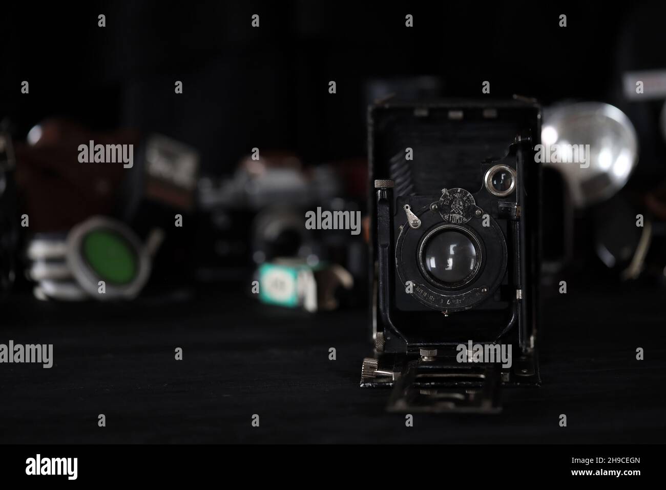 CHARKOV, UKRAINE - 27. APRIL 2021: Fotokor-1 Filmkamera und eine andere alte Retro-Fotoausrüstung auf schwarzem Holztisch in der Dunkelkammer des Fotografen. P Stockfoto