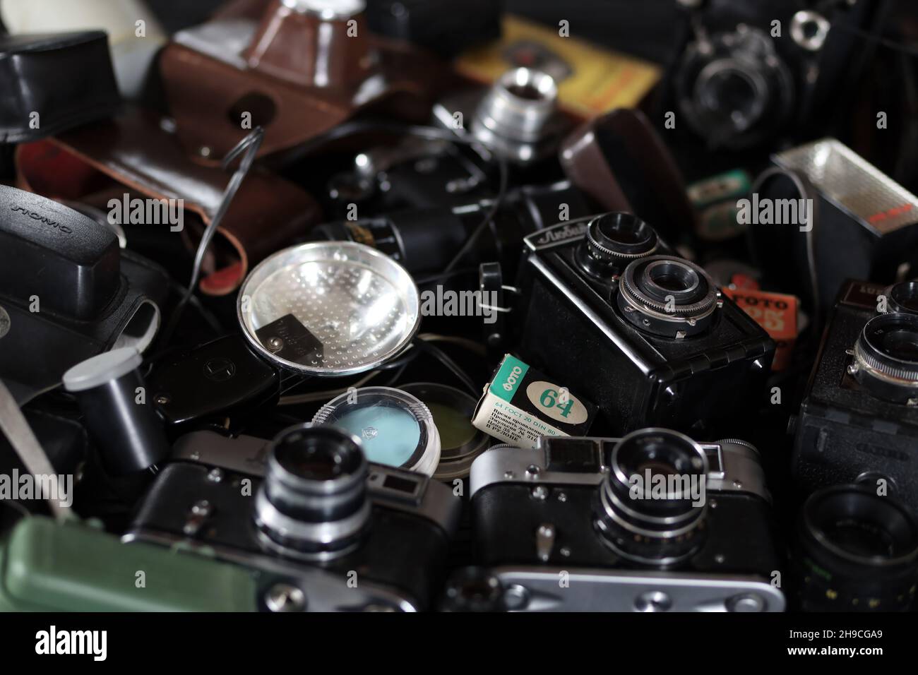 CHARKOV, UKRAINE - 27. APRIL 2021: Filmkameras und eine andere alte Retro-Fotoausrüstung auf schwarzem Holztisch in der Dunkelkammer des Fotografen. Foto Stockfoto