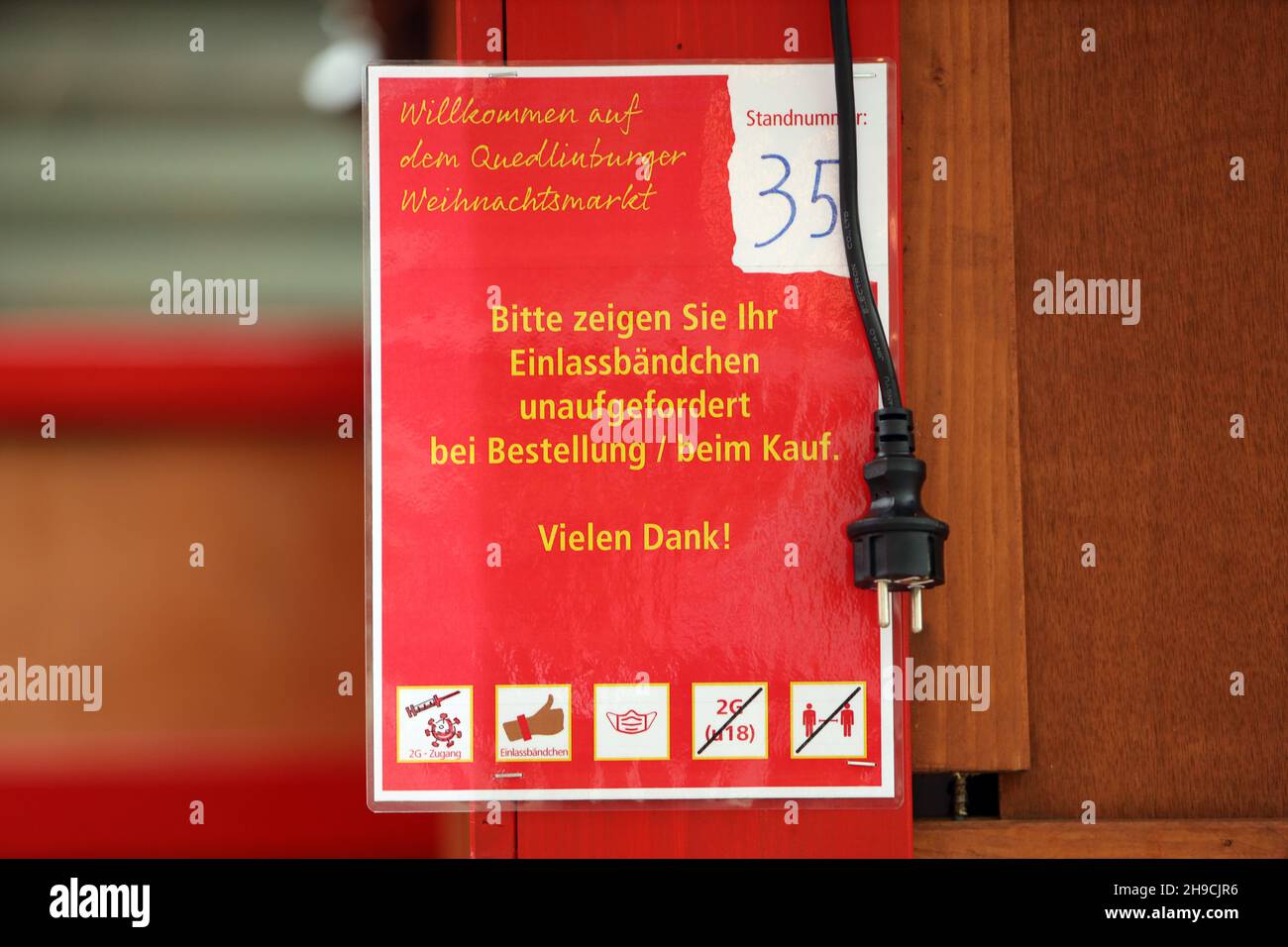 Quedinburg, Deutschland. 06th Dez 2021. Ein Schild mit der Corona-Regel hängt an einer Verkaufshütte auf dem Marktplatz. Seit heute wird der Weihnachtsmarkt in der Adventstadt Quedlinburg abgebaut. Aufgrund der hohen Anforderungen von Corona ist die Besucherzahl in den letzten Tagen stark zurückgegangen. Insgesamt 75 Prozent der Händler baten darum, den Weihnachtsmarkt nach 12 Tagen vorzeitig zu beenden. Die Entscheidung wurde am Sonntag getroffen. Quelle: Matthias Bein/dpa-Zentralbild/ZB/dpa/Alamy Live News Stockfoto