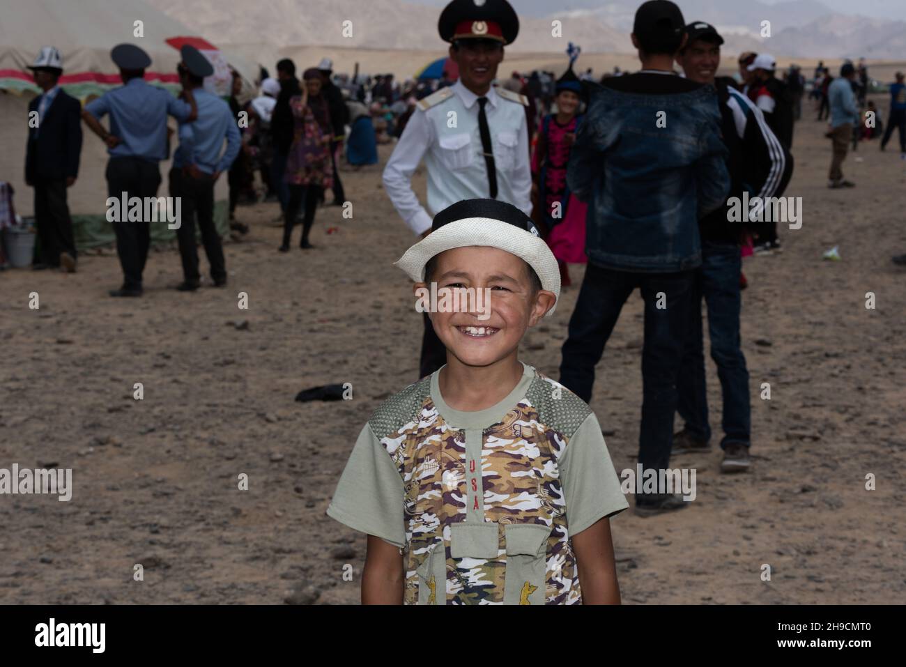 Adjibi lächelt, als er seinen traditionellen Hut beim Murghab Horse Festival in Tadschikistan im August 2019 trug Stockfoto