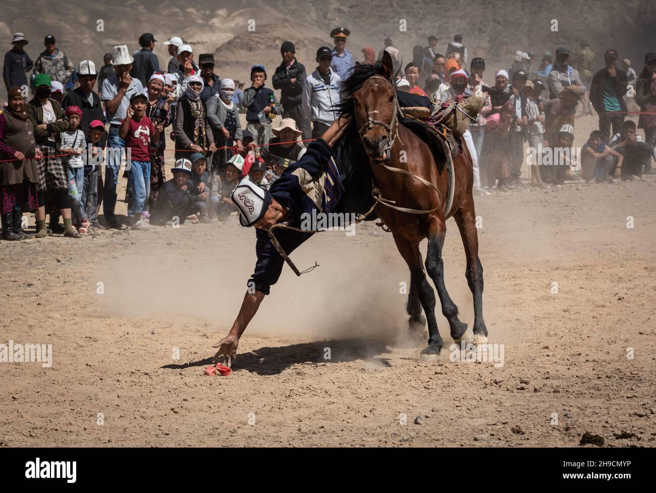 Ein Reiter demonstriert seine Reitkünste in Tyiyn enmei oder schnappt sich die Münze beim Murghab Horse Festival im August 2019. Stockfoto