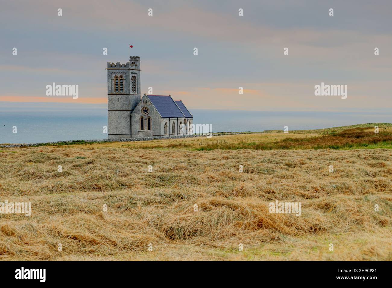 Nach der Ernte auf den Feldern neben der St. Helen's Church auf Lundy Island, Bristol Channel, Devon, England, Großbritannien, bei Sonnenuntergang Heu geschnitten Stockfoto