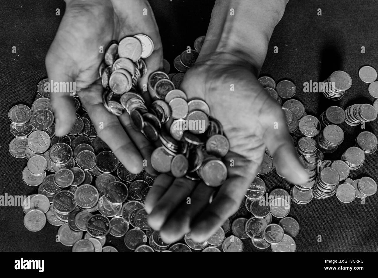 Graustufen-Schuss von Münzen auf männlichen Händen Stockfoto