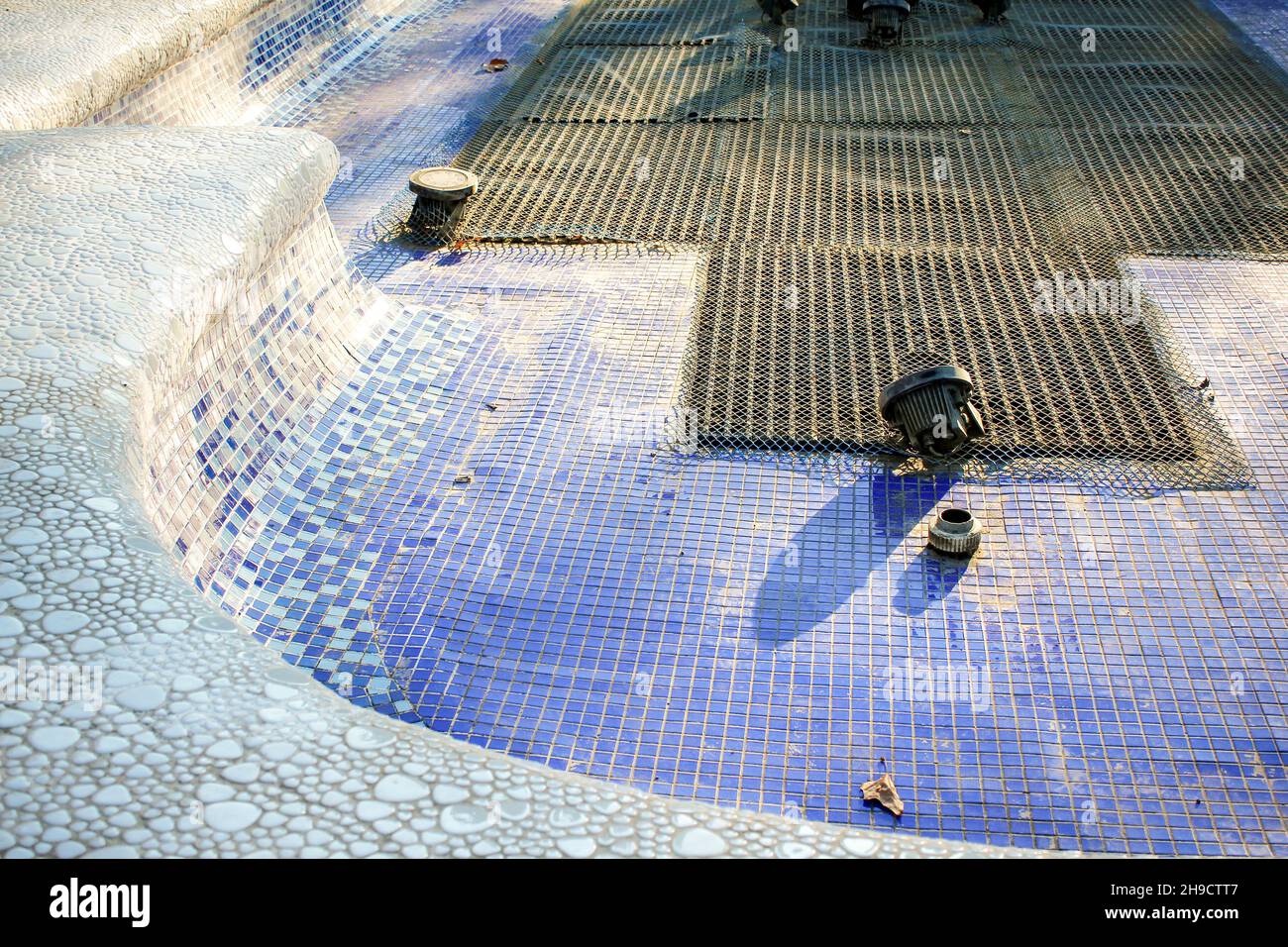 Leerer Brunnen mit blauer und violetter Mosaikschicht. Stockfoto