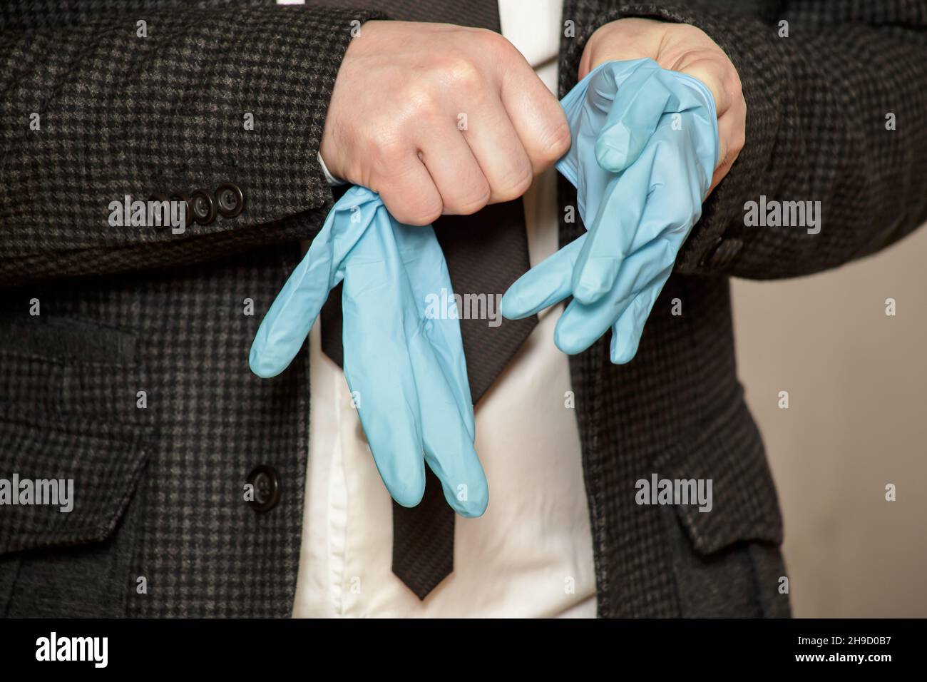 Der Mann zieht medizinische Gummihandschuhe an seinen Händen an. Nahaufnahme. Stockfoto