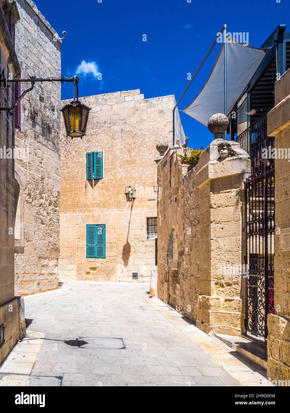 Enge Straße in Mdina, der alten Hauptstadt von Malta, unter klarem blauen Himmel. Stockfoto