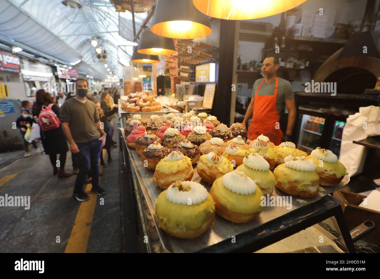 Jerusalem, jüdisches Fest von Chanukka. 6th Dez 2021. Ein Verkäufer verkauft Sufganiyots, runde Gelee-Donuts, die auf dem jüdischen Fest von Hanukkah während der Chanukkah am 6. Dezember 2021 in Jerusalem gegessen wurden. Kredit: Muammar Awad/Xinhua/Alamy Live Nachrichten Stockfoto