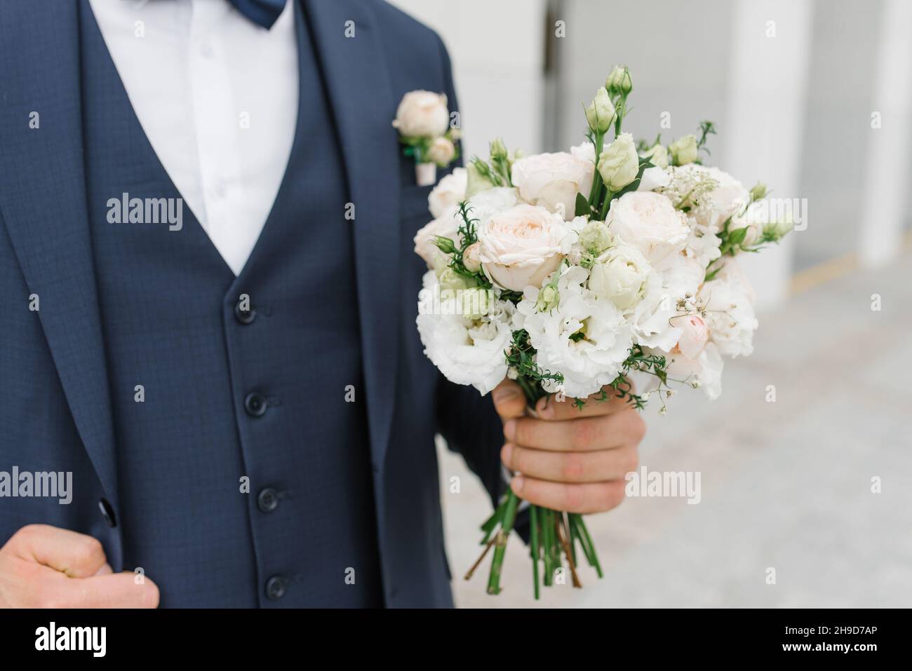 Ein Mann hält einen Hochzeitsstrauß in den Händen. Das Konzept von Valentinstag und Liebe. Hochzeitskonzept. Stockfoto