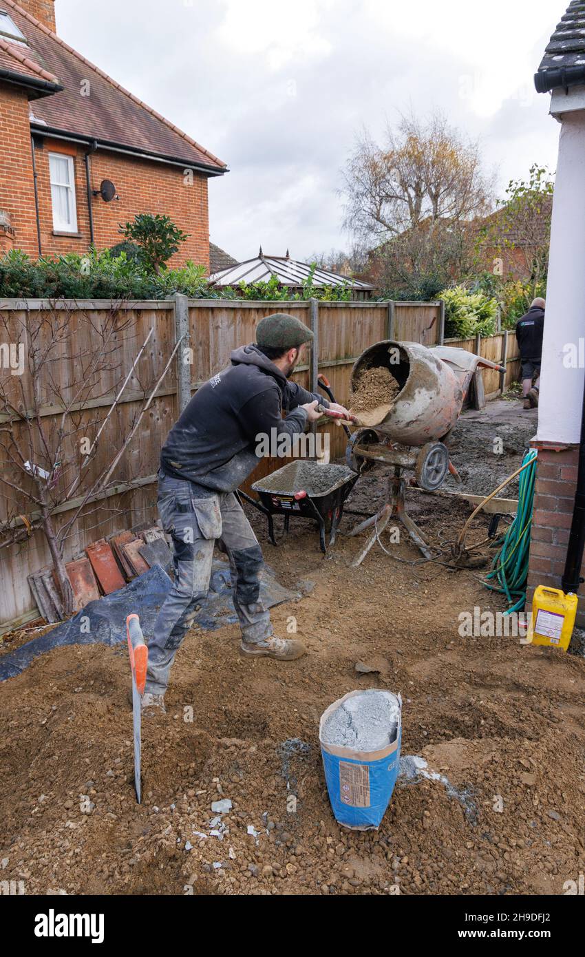 Ein Baumeister, der Zement in einem Zementmischer macht, Beispiel eines Arbeiters, der Handarbeit macht; Bauarbeiten, auf einer Baustelle, England, Großbritannien Stockfoto